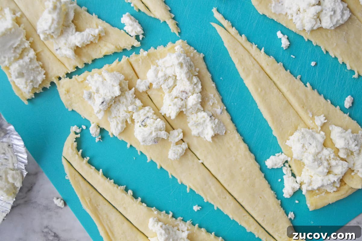 Boursin spread onto the wide end of each dough triangle.