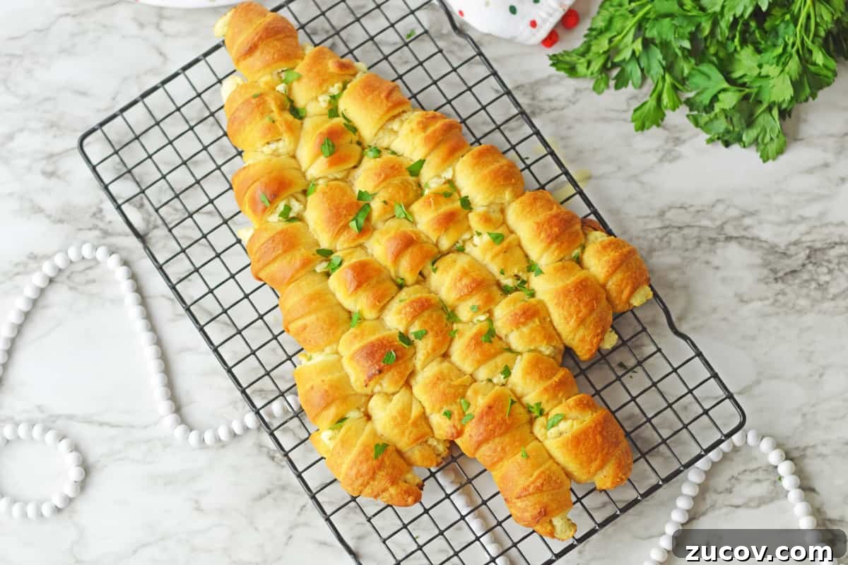 Christmas appetizer made of cheese-stuffed crescents baked in tree shape and topped with butter and parsley.