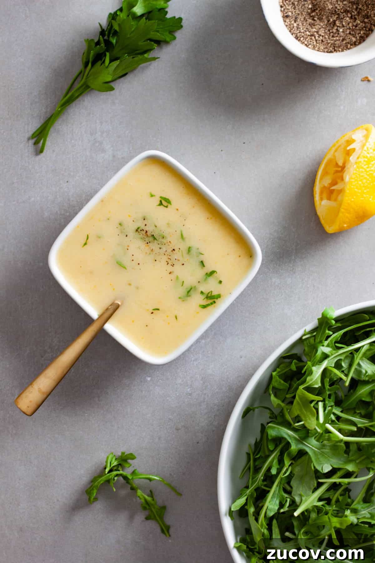 Preserved Lemon Vinaigrette Recipe for Bright, Tangy Salads 2 A small white bowl of preserved lemon vinaigrette topped with chopped parsley.