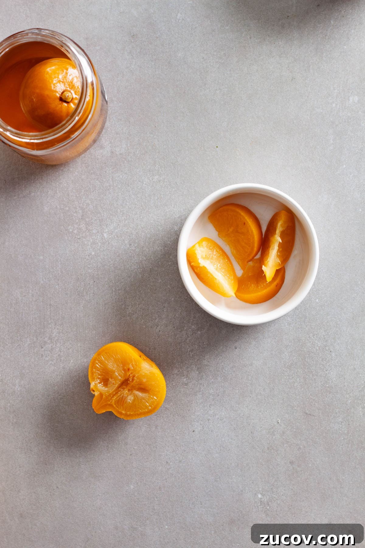 Preserved Lemon Vinaigrette Recipe for Bright, Tangy Salads 9 Sliced preserved lemons in a small white bowl with a glass jar of whole preserved lemons to the side.