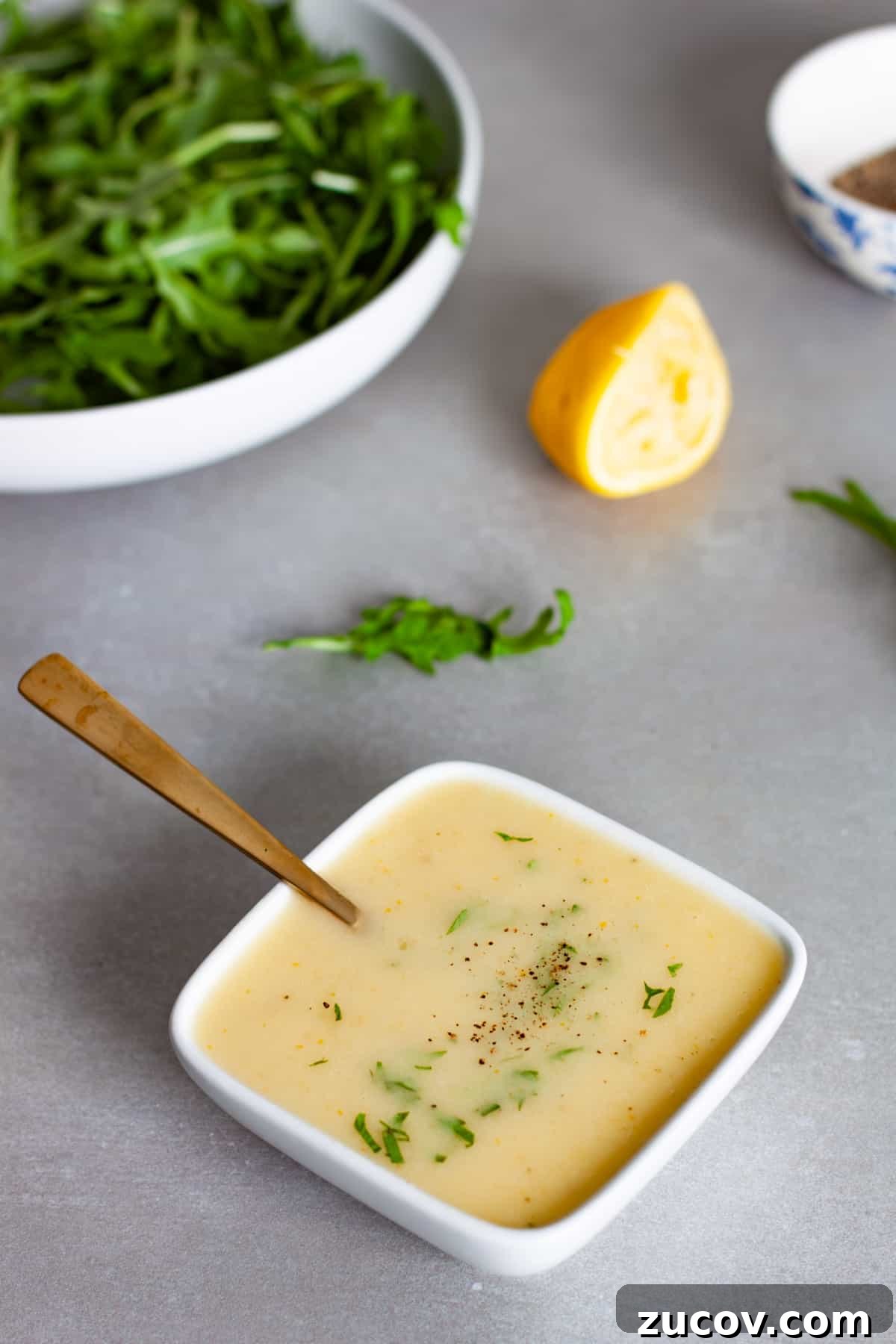Preserved Lemon Vinaigrette Recipe for Bright, Tangy Salads 10 A small white bowl of preserved lemon vinaigrette topped with chopped parsley.