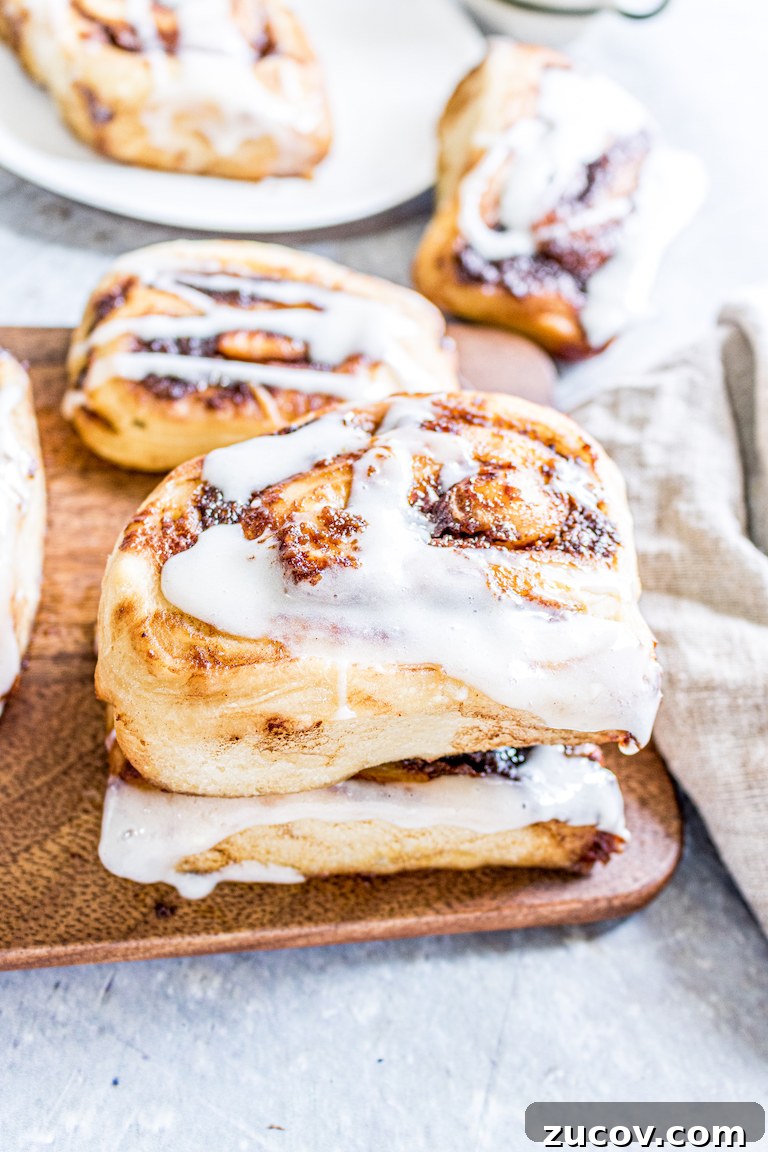 Nutella Pumpkin Cinnamon Rolls with Gooey Chocolate Swirl 5 side view of a finished nutella pumpkin cinnamon roll served on a wooden tray