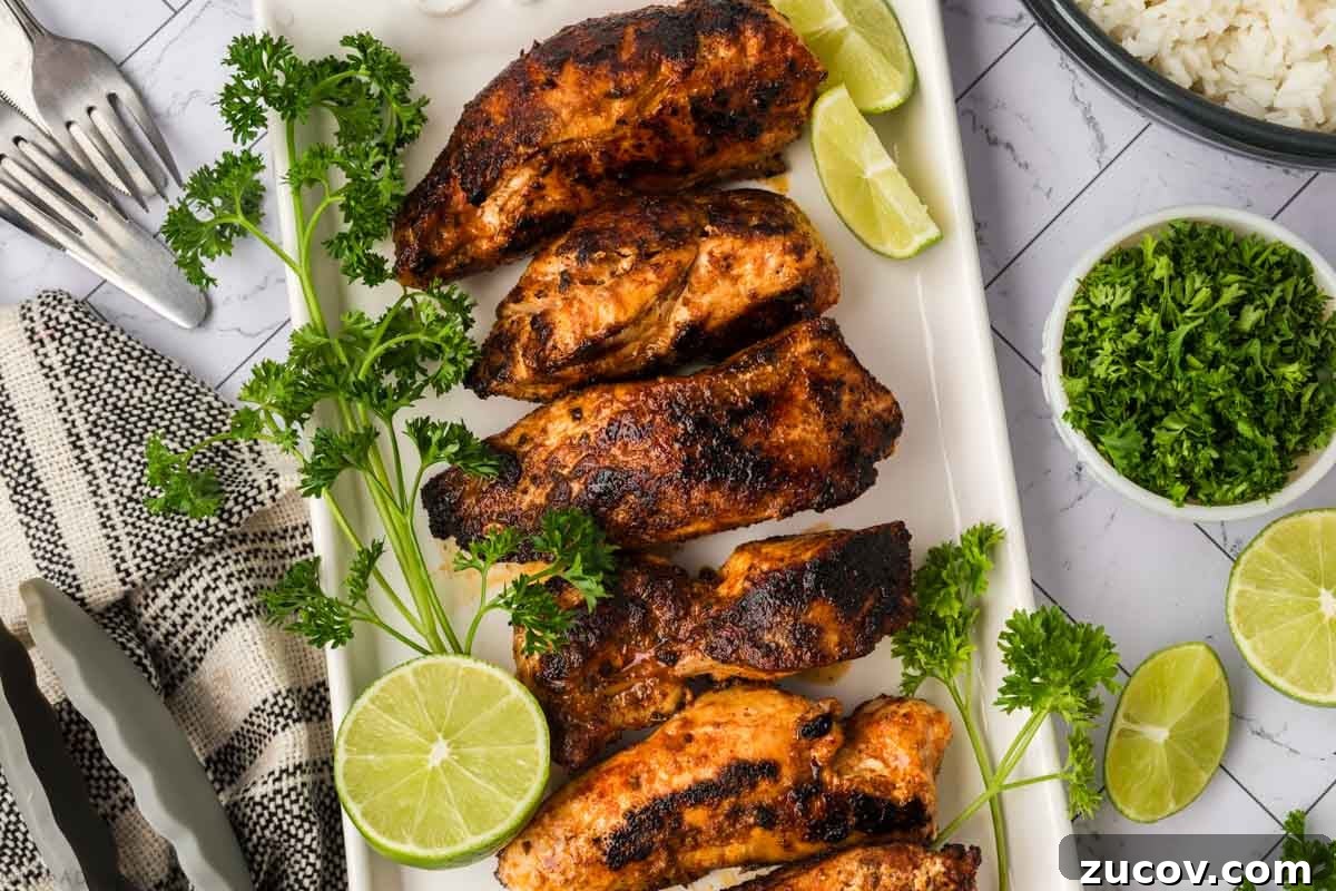 February Blackstone Chicken Recipes: What to Grill This Month 2 Grilled chicken wings with lime and fresh herbs on a white platter, perfect for summer barbecues.