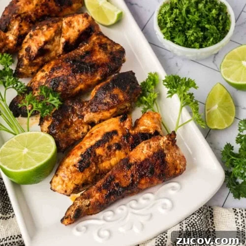 February Blackstone Chicken Recipes: What to Grill This Month 5 Grilled chicken drumsticks with fresh lime and herbs on a white platter