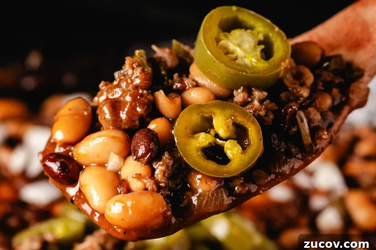 Sweet Rub Recipes to Elevate Your Dinner Menu 5 A scoop of a pit beans recipe seasoned with Sweet Rub on a wooden spatula.