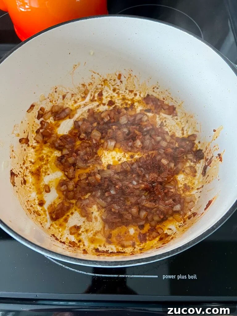Garides Youvetsi: Greek Shrimp with Orzo Recipe 6 frying onion and garlic in tomato paste and olive oil.