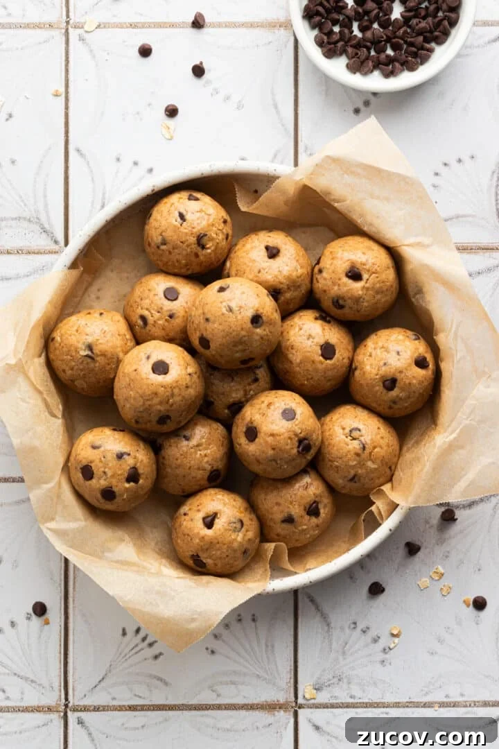 Cookie Dough Protein Balls: No-Bake Snack for Energy and Muscle 3 Cookie dough protein balls in a large bowl on a tiled kitchen counter