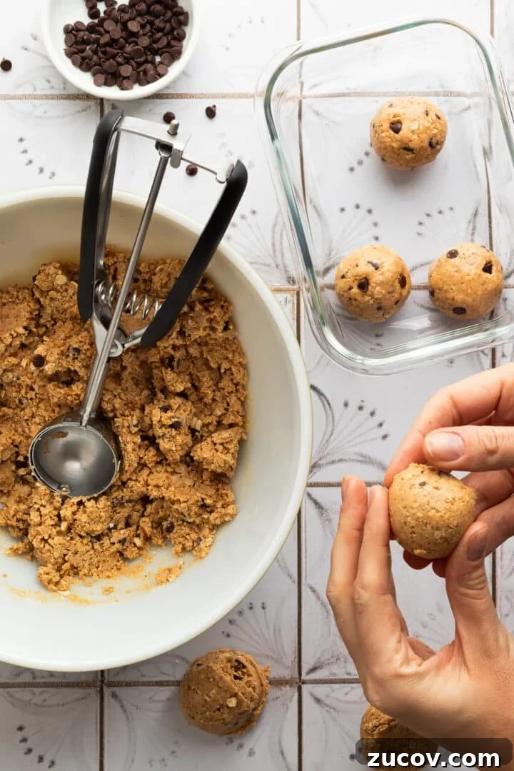 Cookie Dough Protein Balls: No-Bake Snack for Energy and Muscle 7 Cookie scoop forming chocolate chip cookie dough protein balls