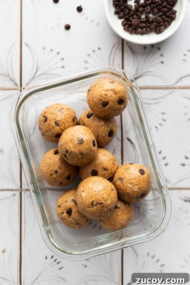 Cookie Dough Protein Balls: No-Bake Snack for Energy and Muscle 8 Cookie dough protein balls in a glass container, ready to be refrigerated
