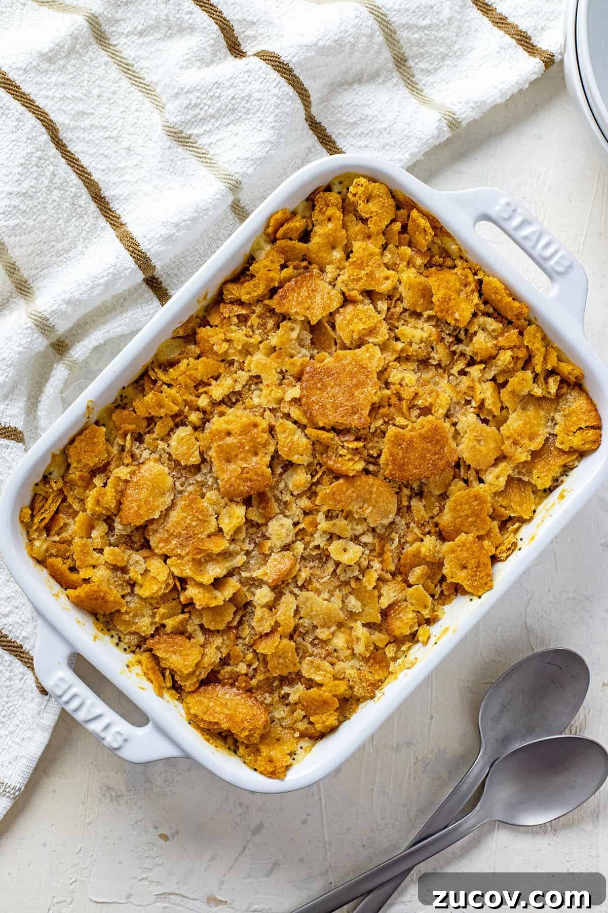 Southern Poppy Seed Chicken Casserole Recipe for Comforting Dinner 5 baked casserole in white rectangular casserole dish with spoons on the side