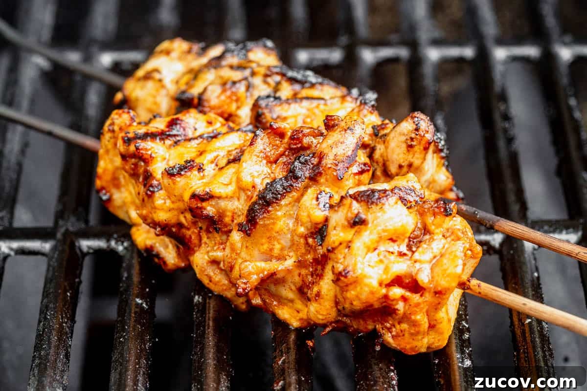 Bang Bang Chicken Skewers Recipe: Creamy Spicy Grilled Skewers 7 bang bang chicken skewers cooking on the grill.