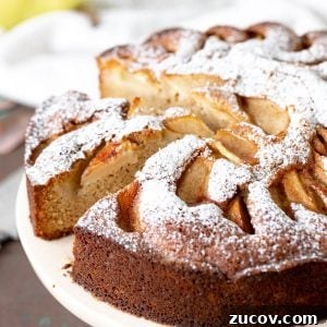 Moist Pear Cake Recipe with Cinnamon Glaze 15 Close up of pear cake on pink cake stand.