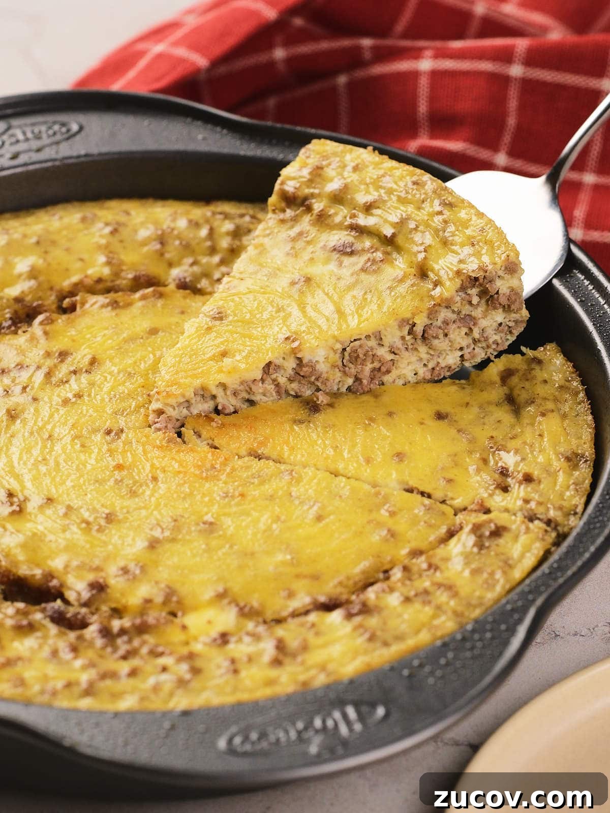 28 Low-Histamine Recipes for Histamine Intolerance-Friendly Meals 11 A metal pan with a baked carnivore casserole of egg and ground meat, with one slice being lifted out on a spatula; a red checkered cloth is in the background.