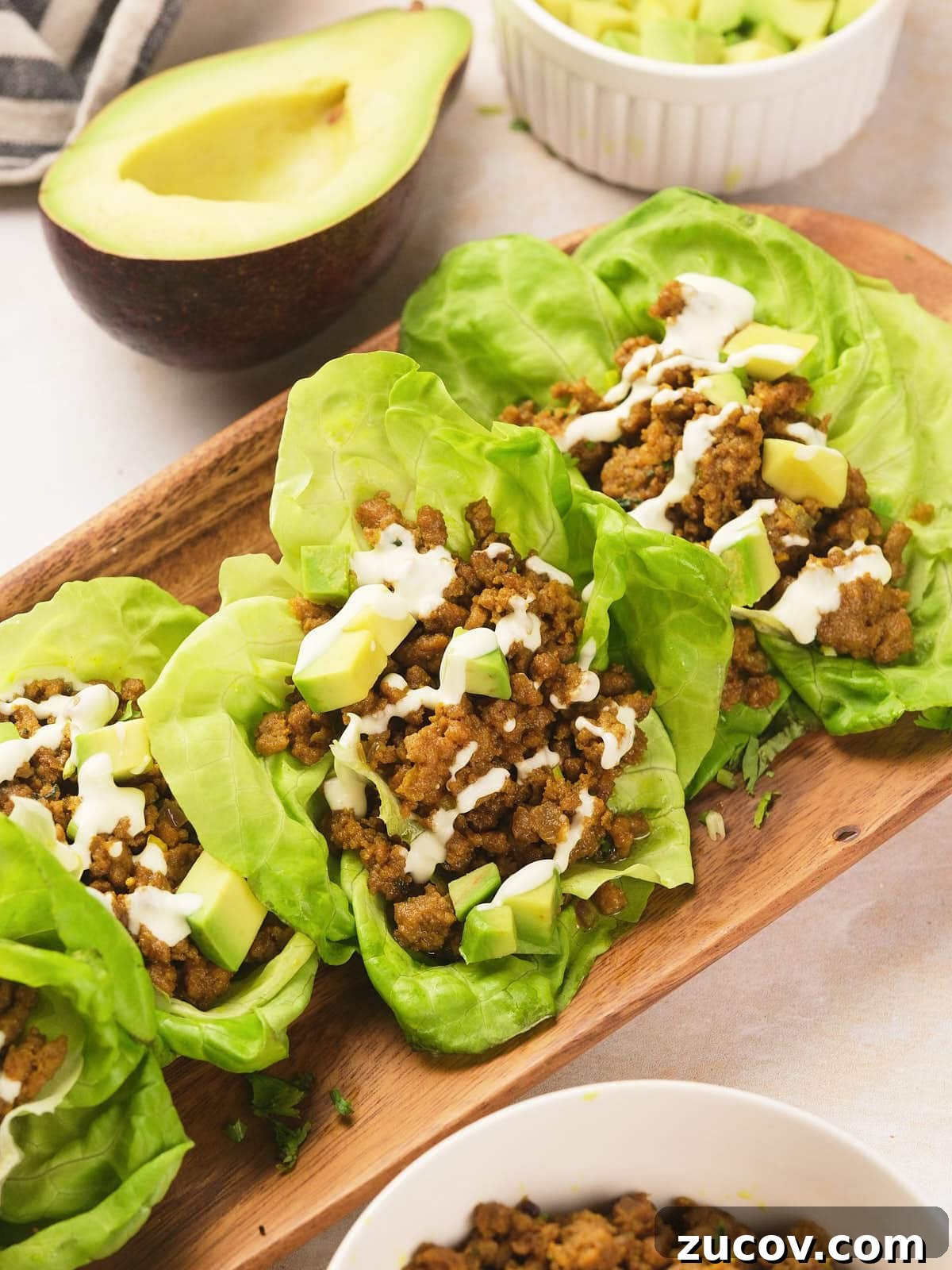 28 Low-Histamine Recipes for Histamine Intolerance-Friendly Meals 16 Three lettuce leaves filled with seasoned ground meat, diced avocado, and a drizzle of white sauce.