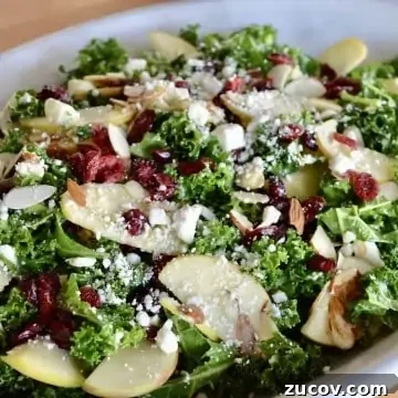 Kale, Cranberry & Feta Salad with Lemon Vinaigrette 7 Kale Cranberry Feta Salad with almonds and apples in a white serving platter.