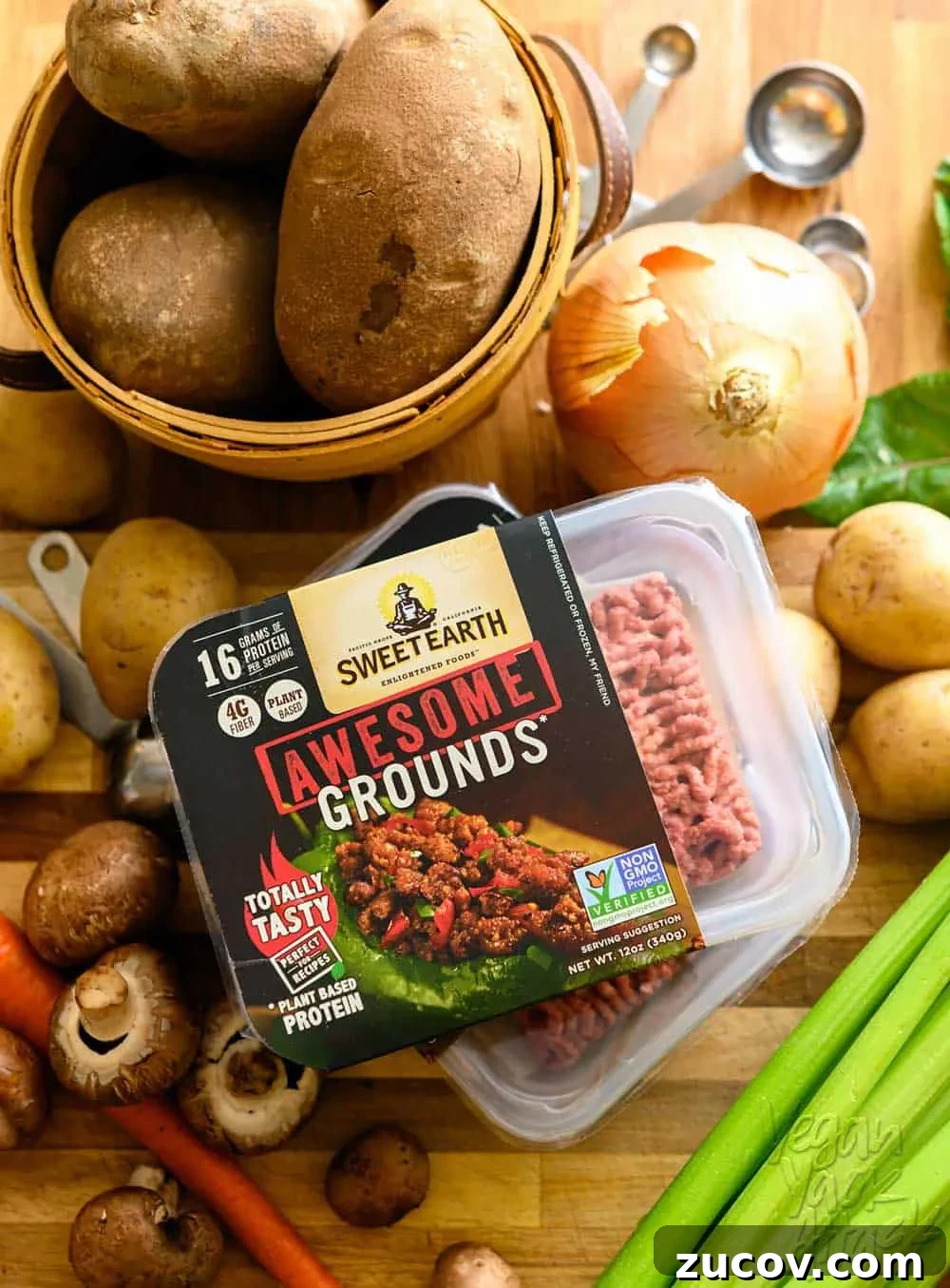 Savory Vegan Shepherd’s Pie with a Flavorful Twist 3 A container of Sweet Earth Foods Awesome grounds surrounded by potatoes, onion, celery, and mushrooms, on top of a cutting board.