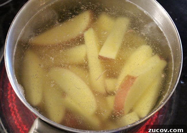 Crispy Roasted Parmesan Potato Wedges with Garlic and Herbs 5 Boiling potato wedges in a large pot.