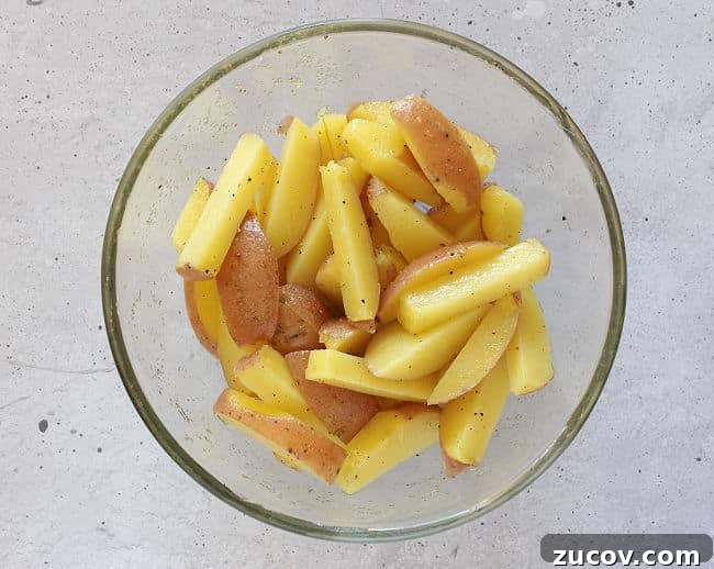 Crispy Roasted Parmesan Potato Wedges with Garlic and Herbs 7 Tossing unbaked potatoes with olive oil.