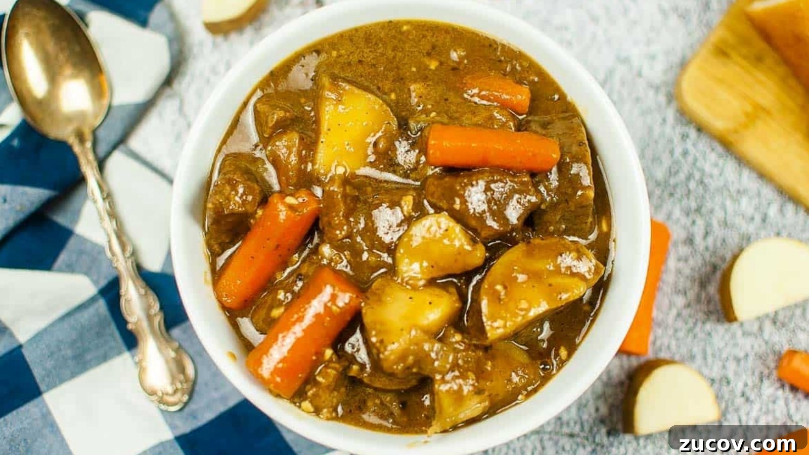 15 Irresistible St. Patrick’s Day Beef Recipes to Make Again and Again 4 Top view of a bowl of Guinness beef stew with a black checked napkin and a spoon.