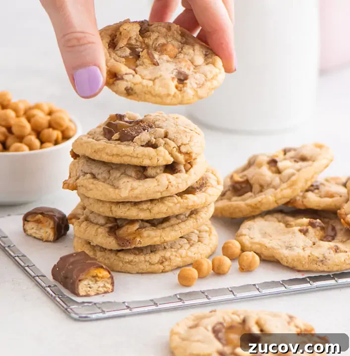Twix Cookie Recipes: Homemade Bars and Crunchy Bites 5 stack of cookies on a wire rack with a hand lifting one cookie off