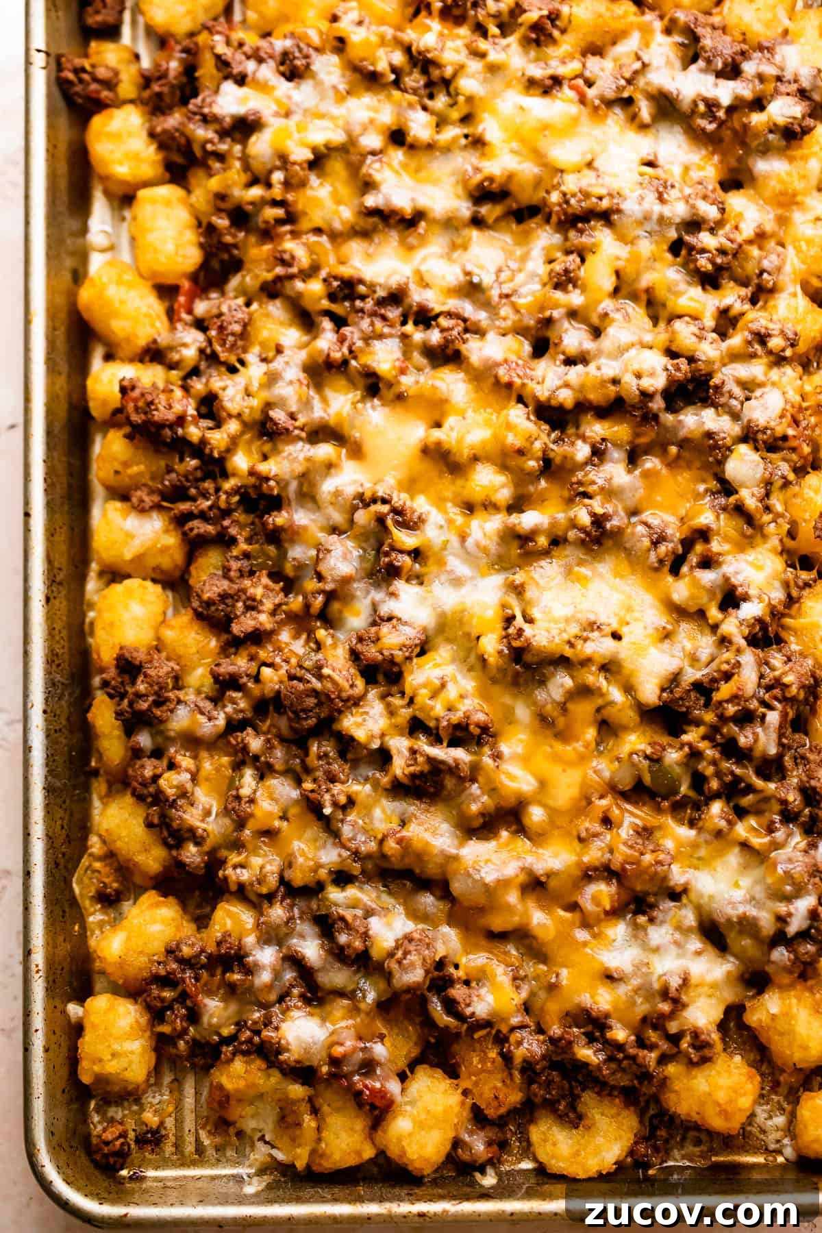 baking sheet with tater tots topped with ground beef and melted cheese