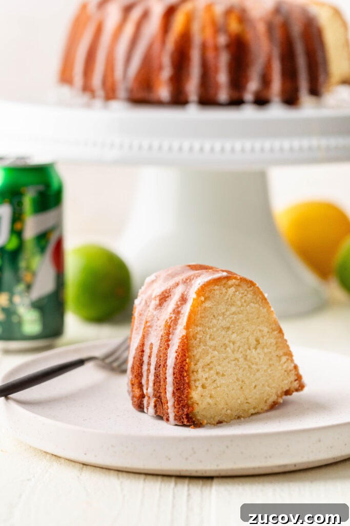 7-Up Pound Cake Recipe: Classic Southern Soul Food Treat 2 slice of 7-up pound cake on a white plate with a can of 7-up, lemon, lime and whole cake in the background