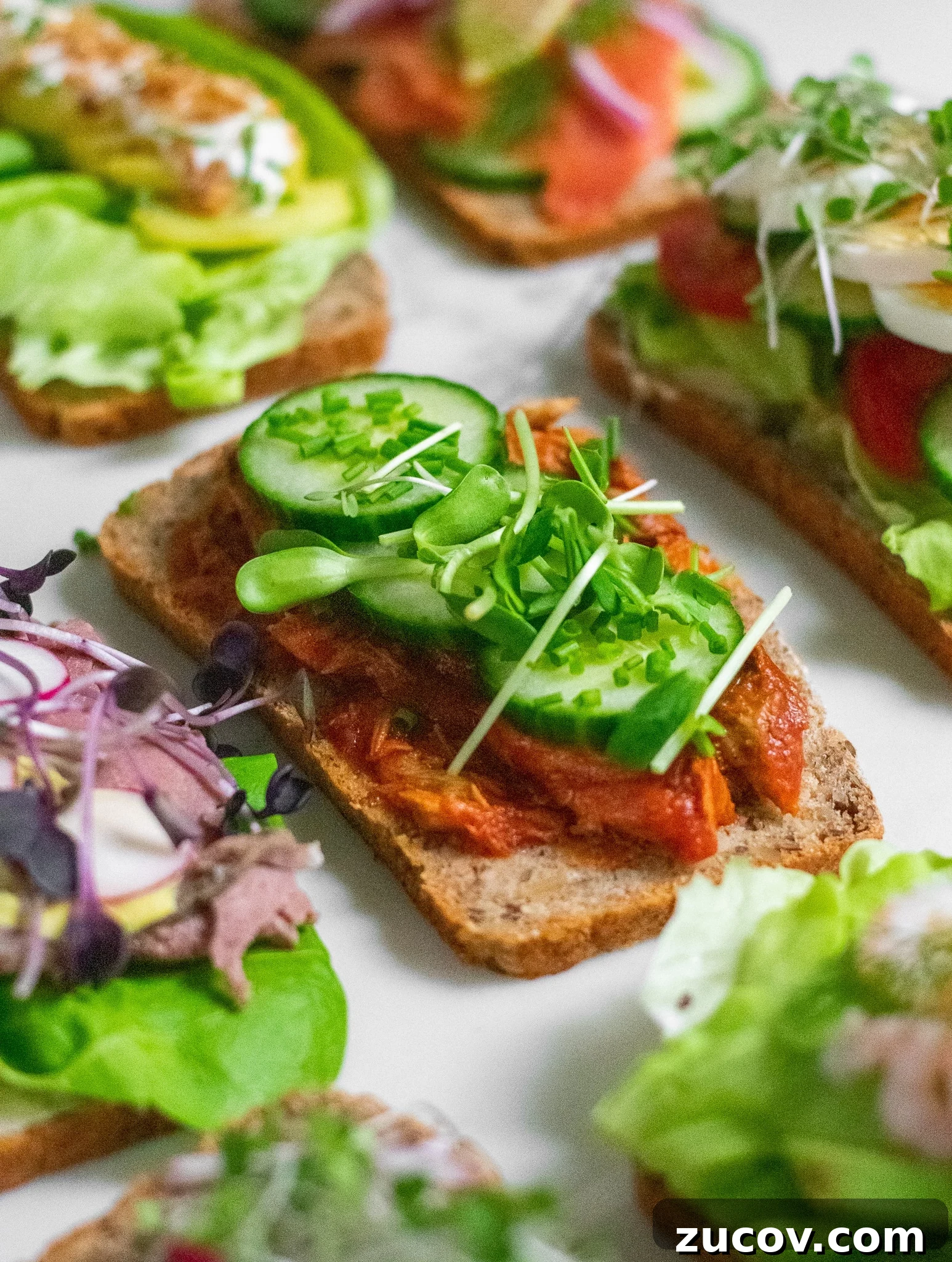 How a Sandwich Became Denmark’s Iconic Smørrebrød: Complete Guide 11 A rye bread open faced sandwich topped with mackerel in tomato sauce, cucumber, chives, and micro greens.