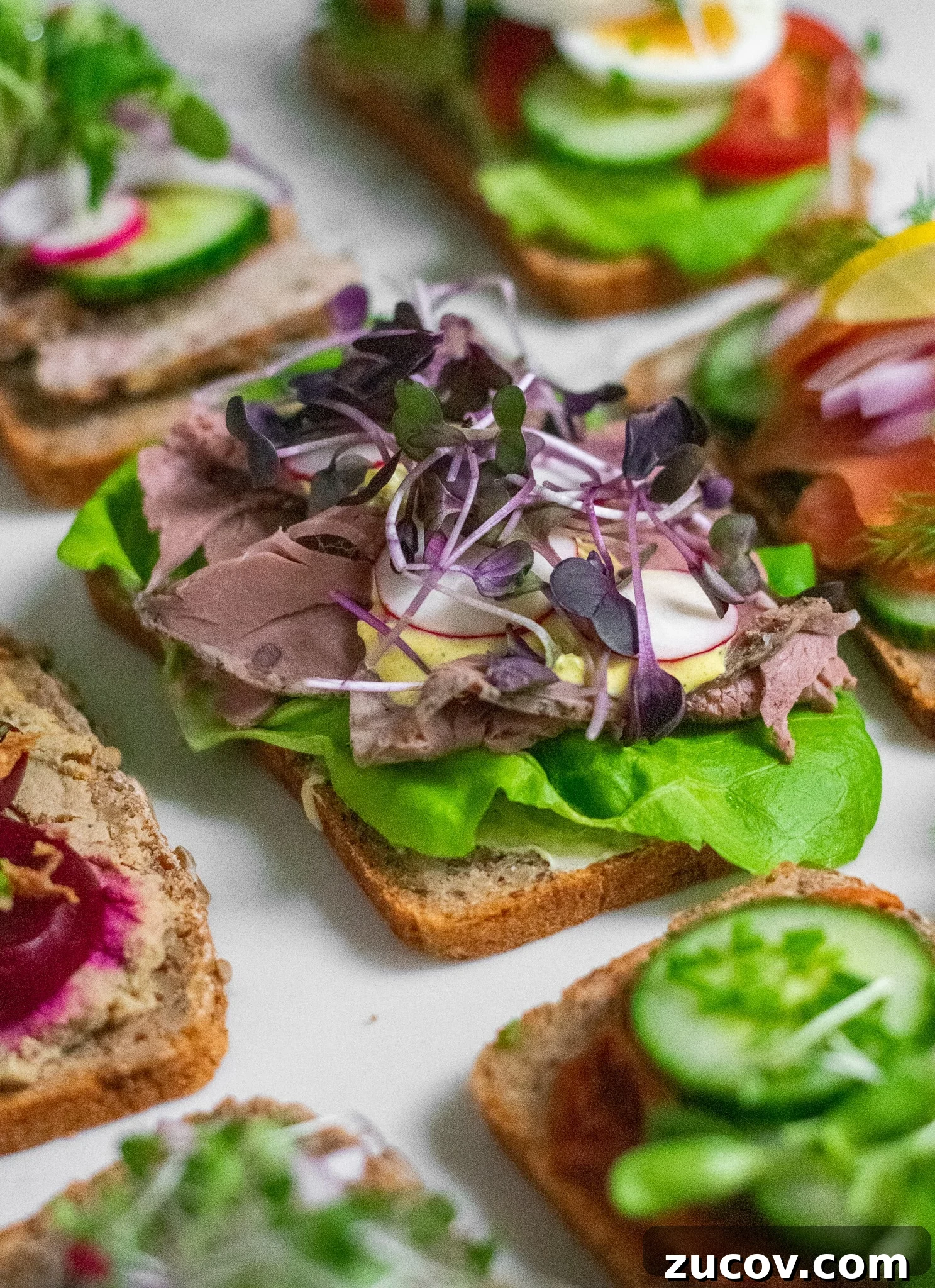 How a Sandwich Became Denmark’s Iconic Smørrebrød: Complete Guide 16 A rye bread open faced sandwich topped with lettuce, roast beef, remoulade, radish, and micro greens.