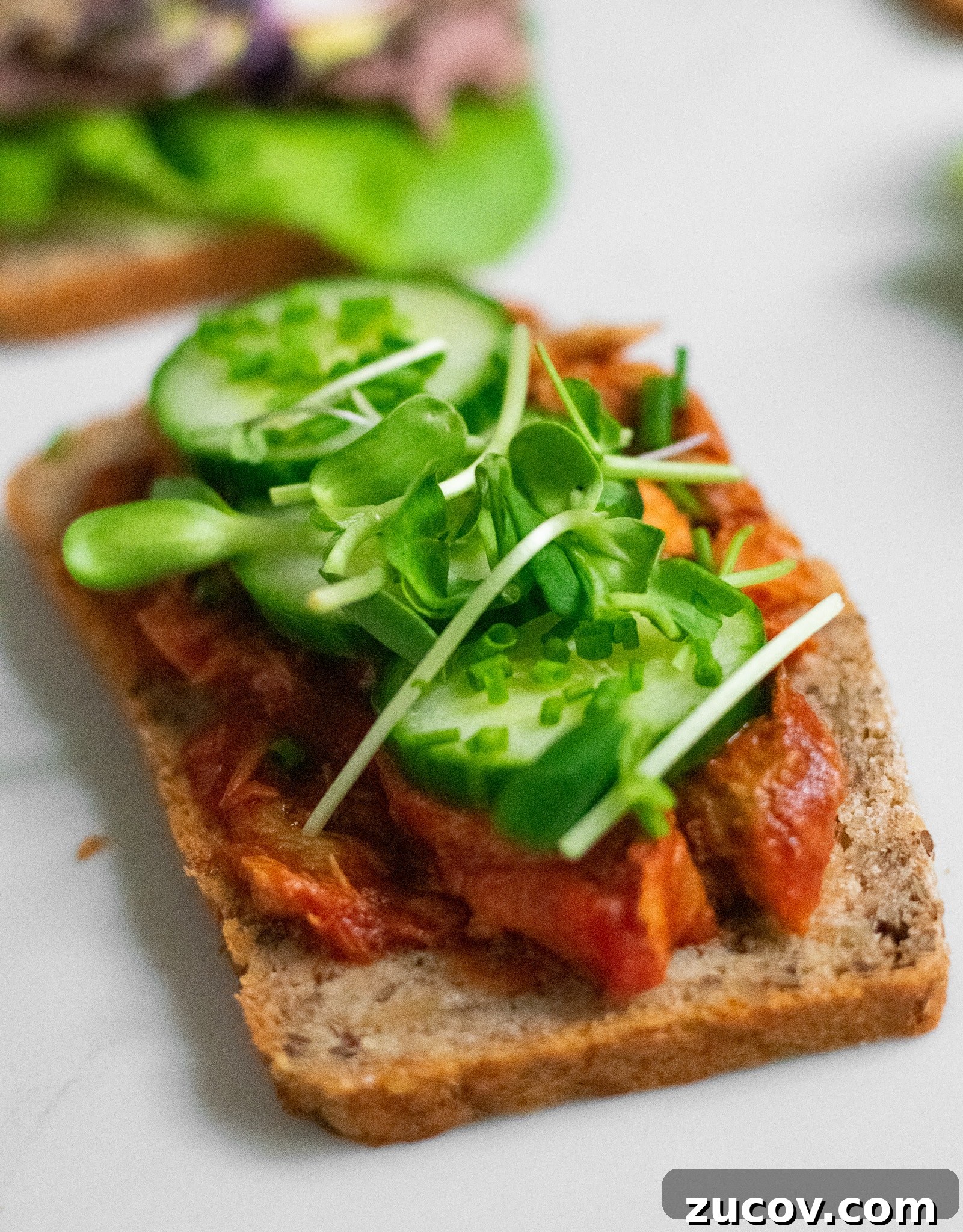 How a Sandwich Became Denmark’s Iconic Smørrebrød: Complete Guide 24 A rye bread open faced sandwich topped with mackerel in tomato sauce, cucumber, chives, and micro greens.
