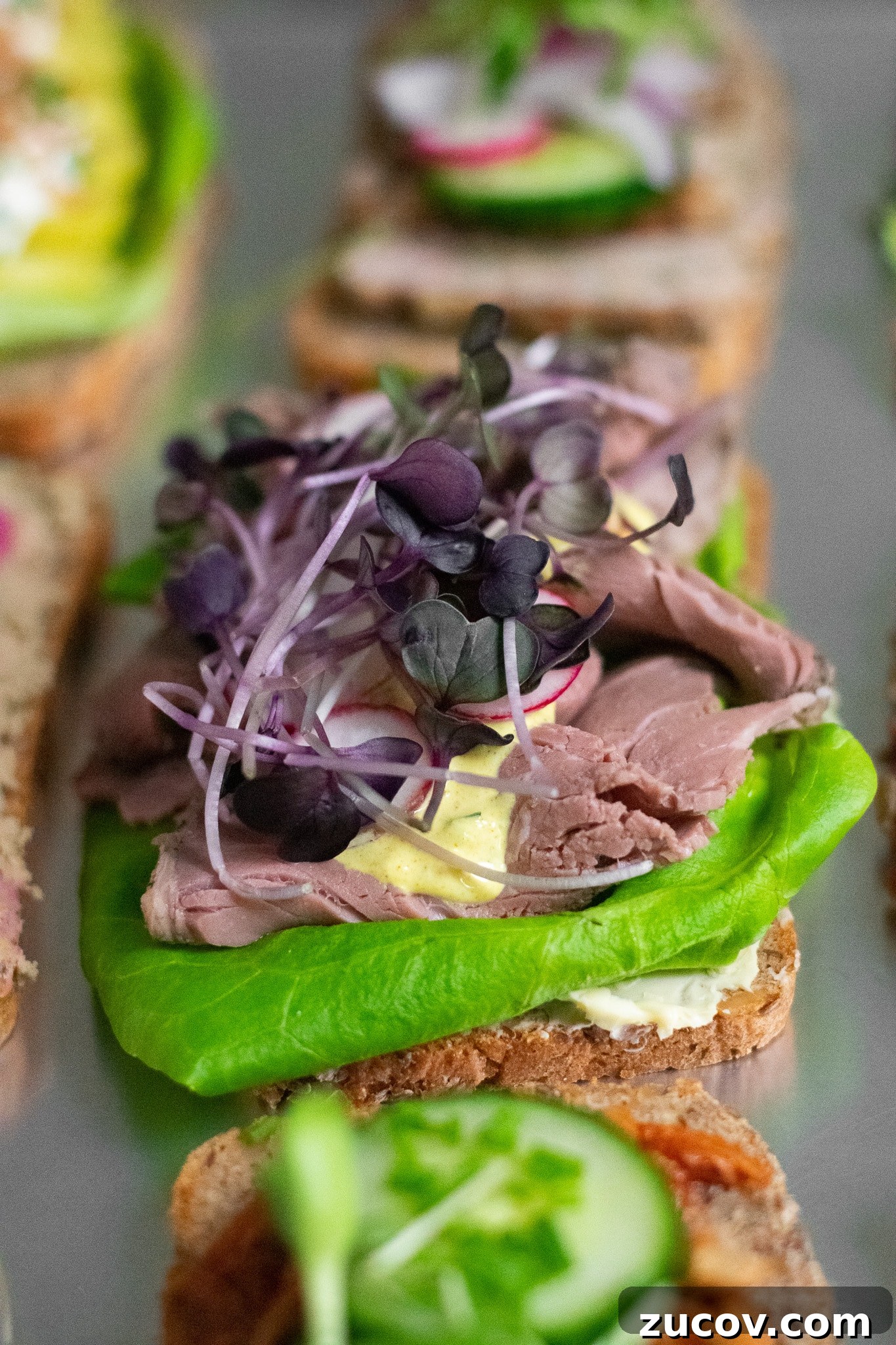 How a Sandwich Became Denmark’s Iconic Smørrebrød: Complete Guide 5 A rye bread open faced sandwich topped with lettuce, roast beef, remoulade, radish, and micro greens.