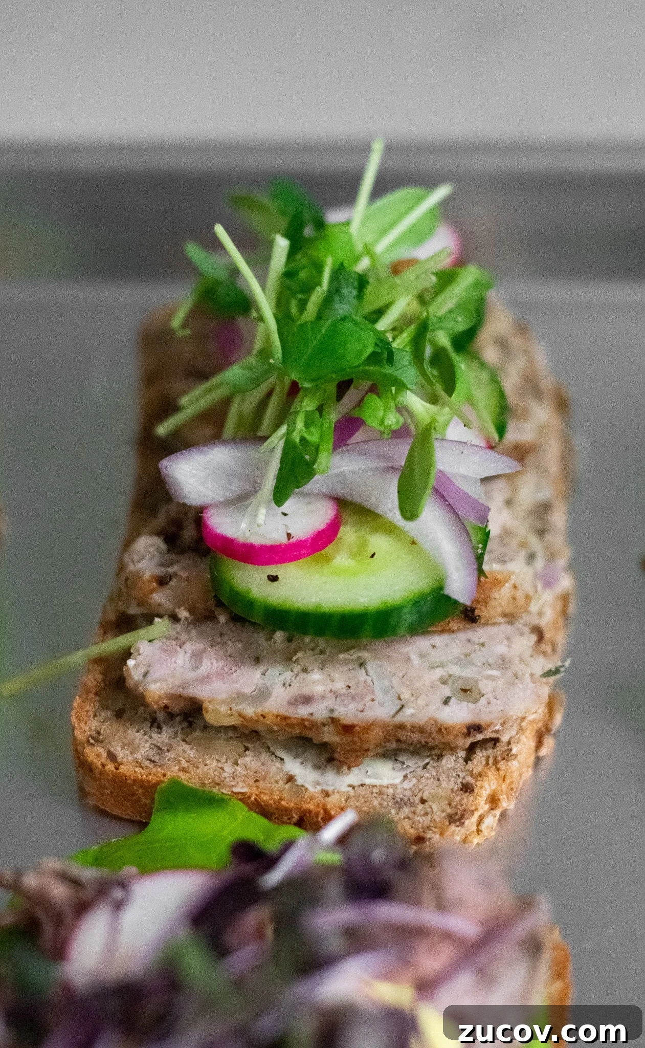 How a Sandwich Became Denmark’s Iconic Smørrebrød: Complete Guide 9 A rye bread open faced sandwich topped with danish meatballs, cucumber, radish, onion, and micro greens.