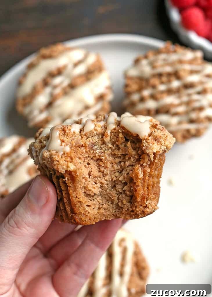 Paleo Coffee Cake Muffins Recipe — Gluten-Free Morning Treat 4 hand holding a bite taken out of a paleo coffee cake muffin