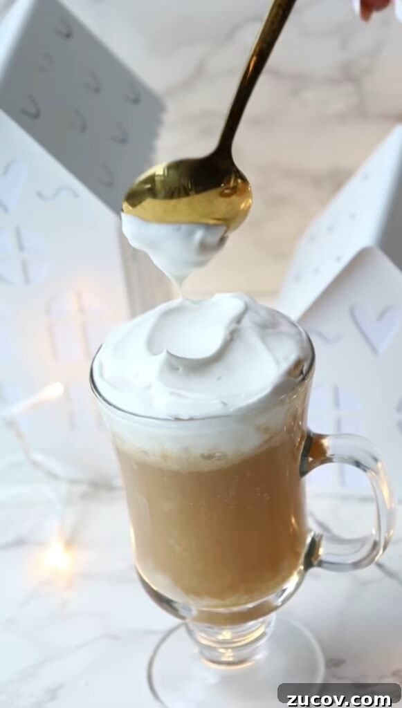 How to Make Authentic Harry Potter Butterbeer at Home 4 the harry potter butterbeer recipe in a tall drinking class with whipped cream on topo