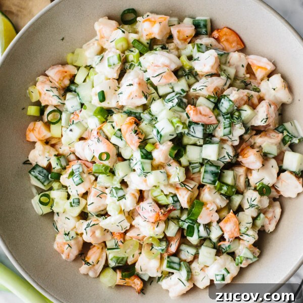 A large serving bowl of cucumber shrimp salad
