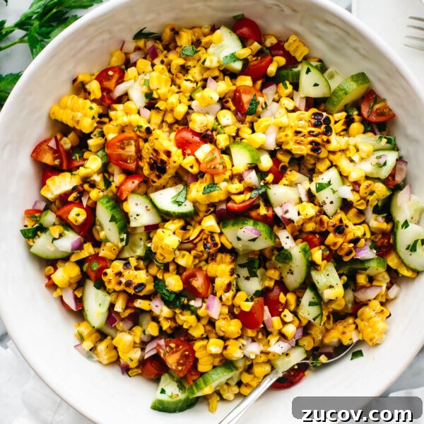 A large white bowl of corn salad next to parsley and a napkin