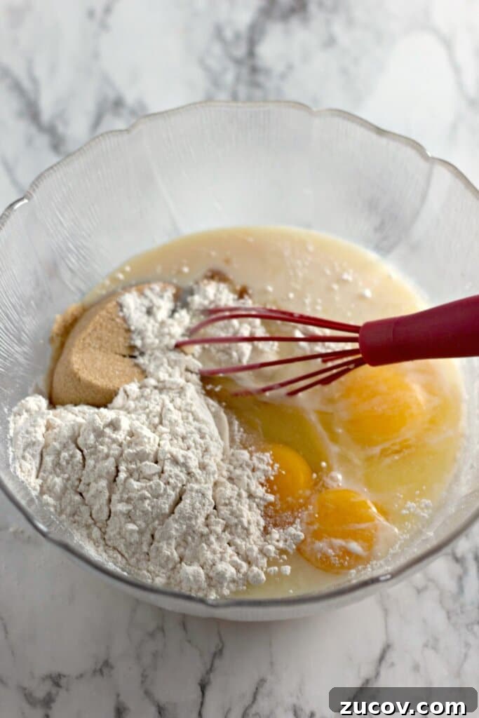 Coconut Butter Bars Recipe with Creamy Coconut Filling 7 Flour and eggs being added to batter in a large bowl.