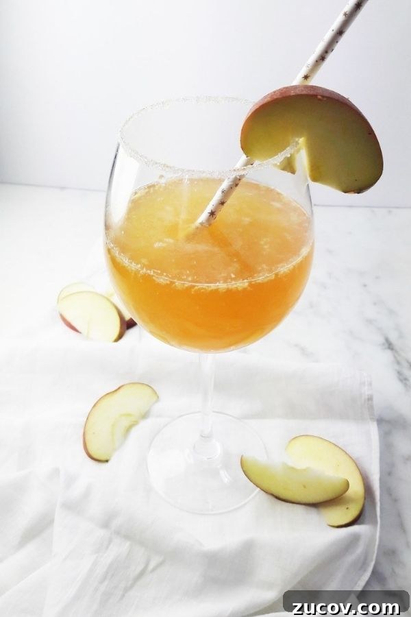 20 Must-Try Apple Cider Cocktails for Fall Gatherings 5 a simple apple cider cocktail filled with apple, lemon and ginger in a tall wine glass!